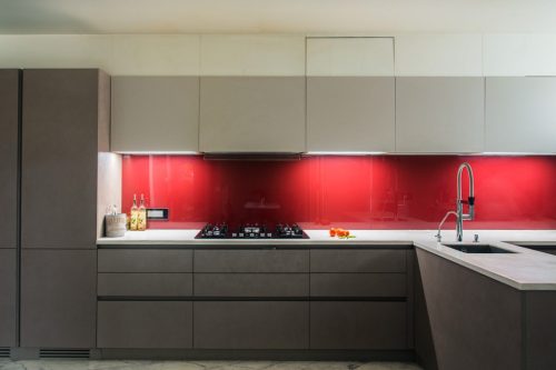 Modern Kitchen Design with Bright Red Backsplash in Glossy Finish in a Muted Kitchen - Beautiful Homes